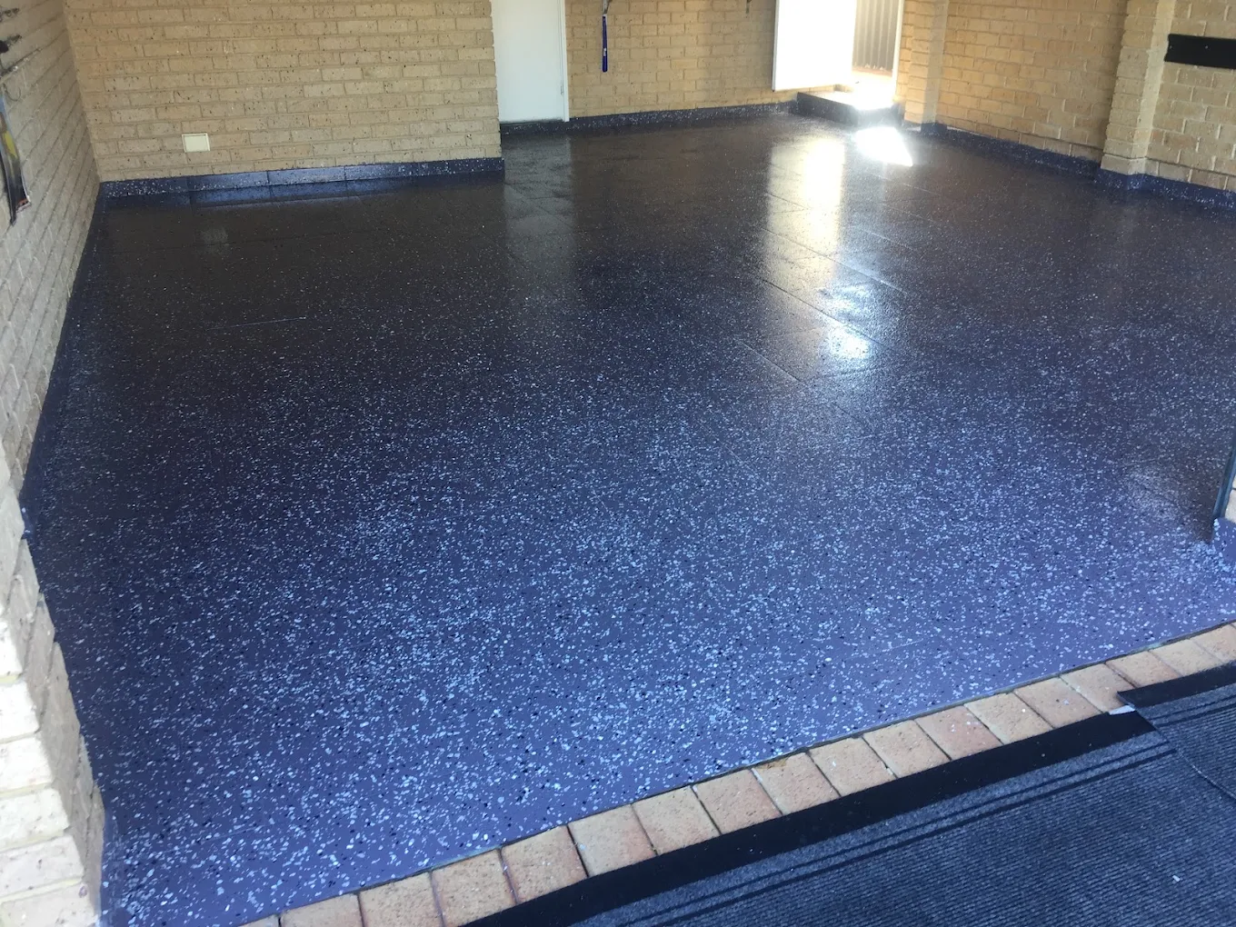 Overlay being sprayed onto a properly prepared concrete surface