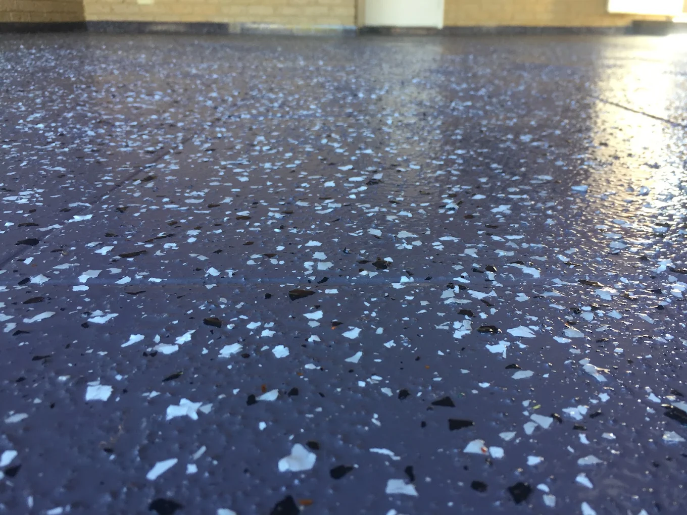 Blue-grey flake epoxy floor coating with white and black flakes under a gloss topcoat