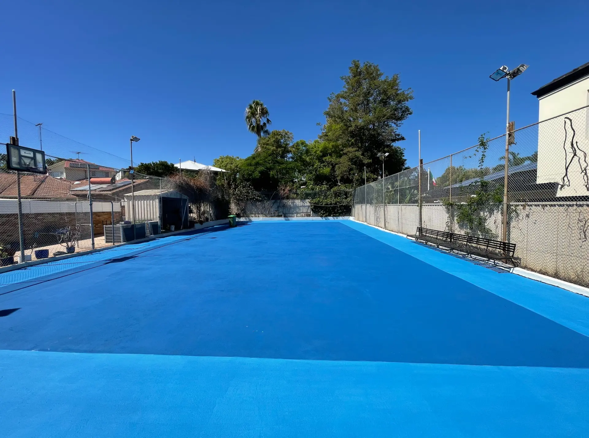 Two-tone blue StreetBond basketball court coating across a full residential sports court under clear Perth sky