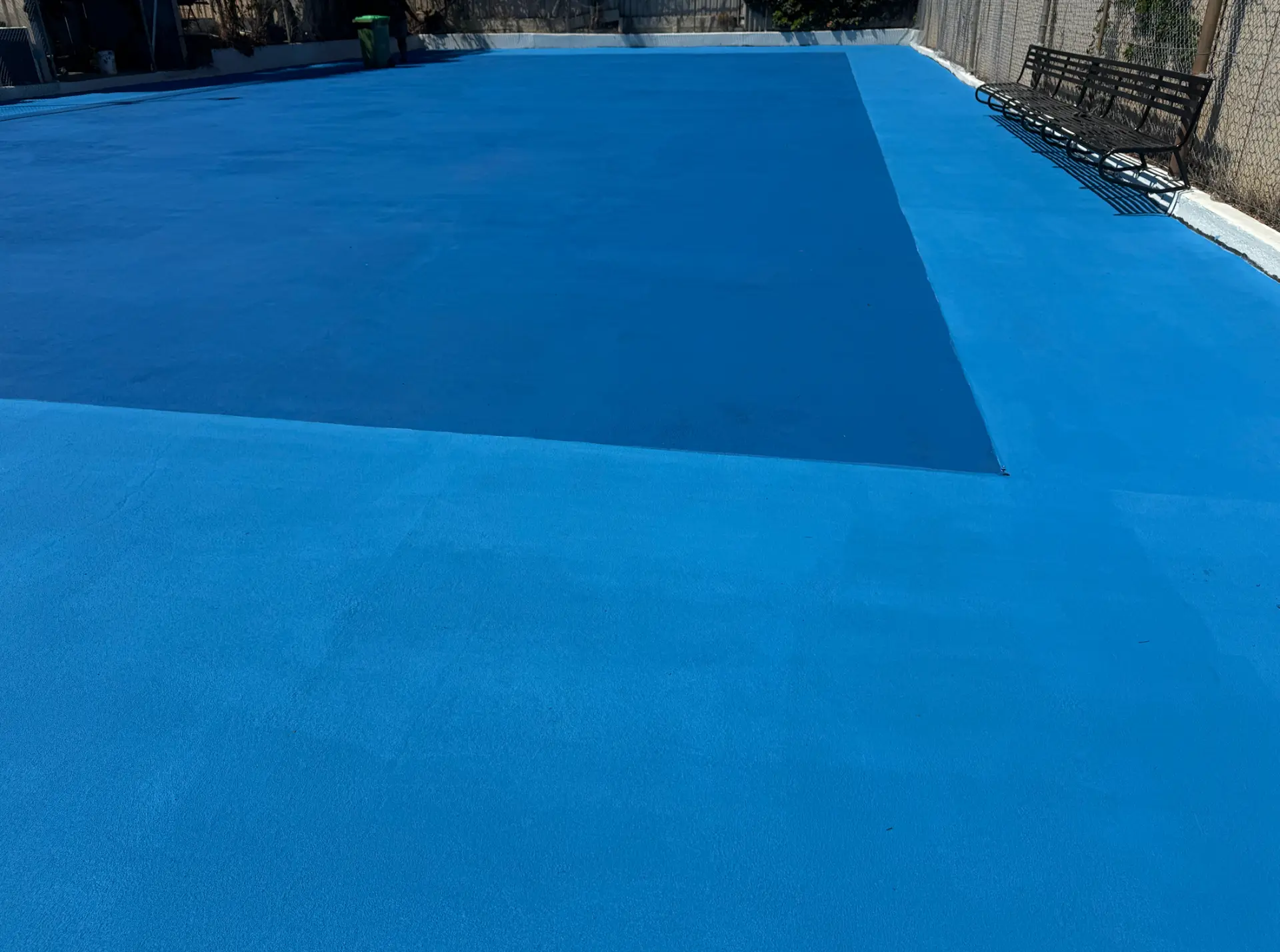 Finished blue StreetBond court showing the darker inner playing area against the lighter blue surround